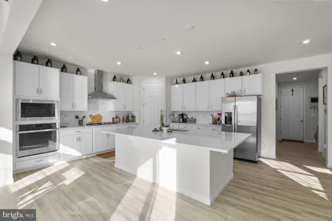 a large dining hall with stainless steel appliances granite countertop a stove and a living room view