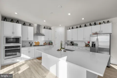 a kitchen with stainless steel appliances granite countertop a stove and a wooden floors