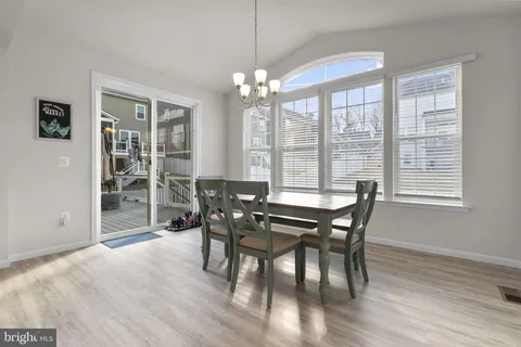 a kitchen with a dining table chairs stainless steel appliances and cabinets
