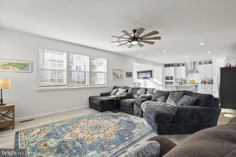 a living room with furniture and a view of kitchen