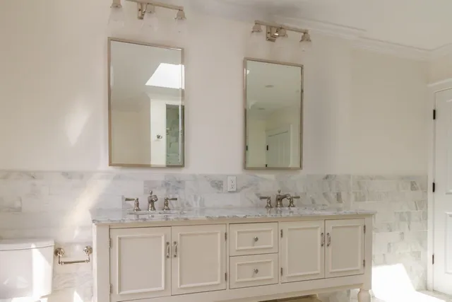 a bathroom with double sink and a mirror