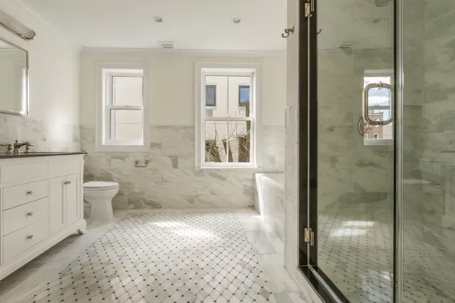 a bathroom with a double vanity sink toilet and shower