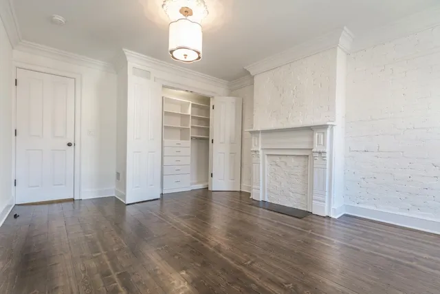 an empty room with wooden floor & windows and closet
