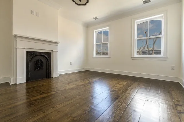 an empty room with wooden floor and a window