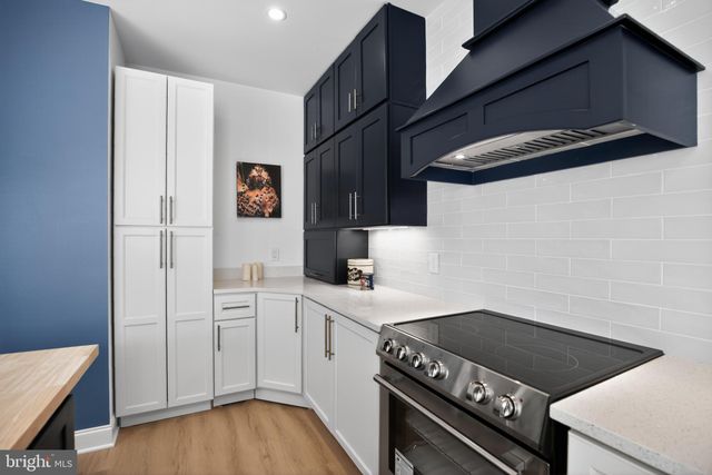 a kitchen with a sink cabinets and wooden floor
