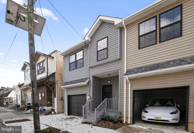 a front view of a house with a road and garage