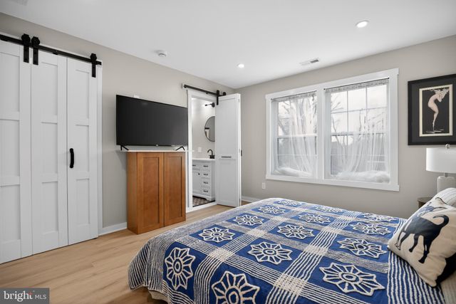 a bedroom with a large bed and a flat screen tv