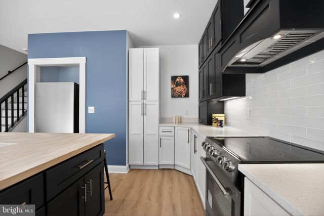 a kitchen with a sink a table and chairs in it