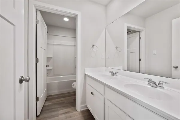 a bathroom with a double vanity sink and mirror with shower