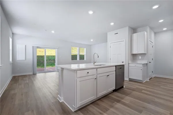 a large kitchen with a lot of counter space and wooden floor