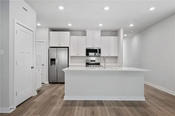 a view of kitchen with stainless steel appliances a refrigerator and a stove top oven