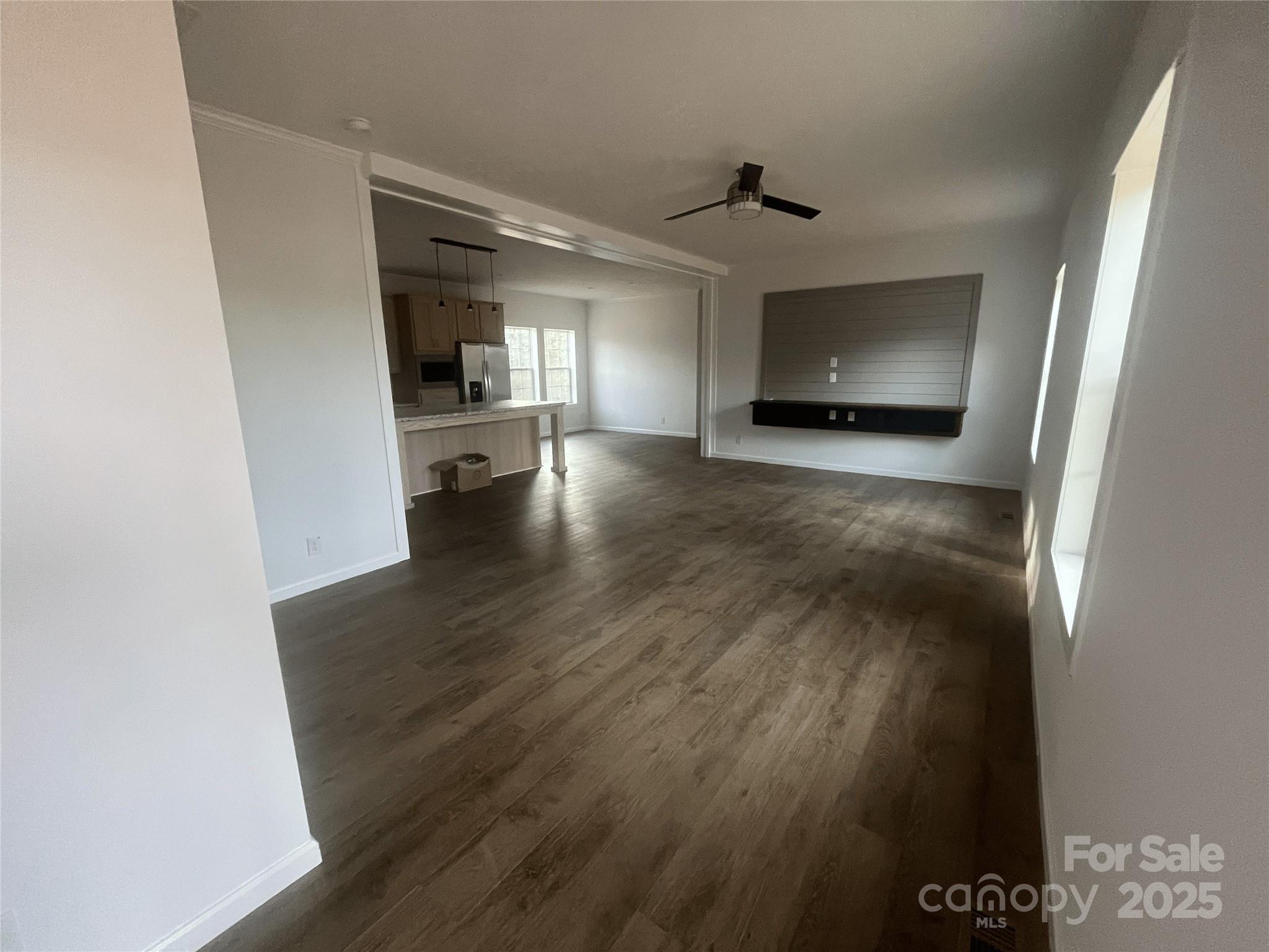 2070 Travis Road Conover, NC 28613 - Photo 5 of 8 a view of a hallway to an empty room with wooden floor and a window