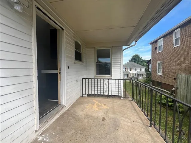 a view of a porch with wooden floor and iron stairs