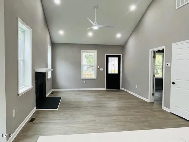 an empty room with windows and fireplace