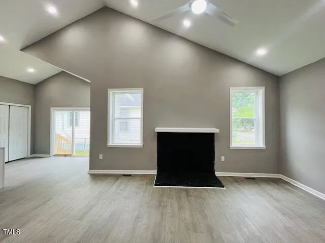 an empty room with wooden floor and a fireplace