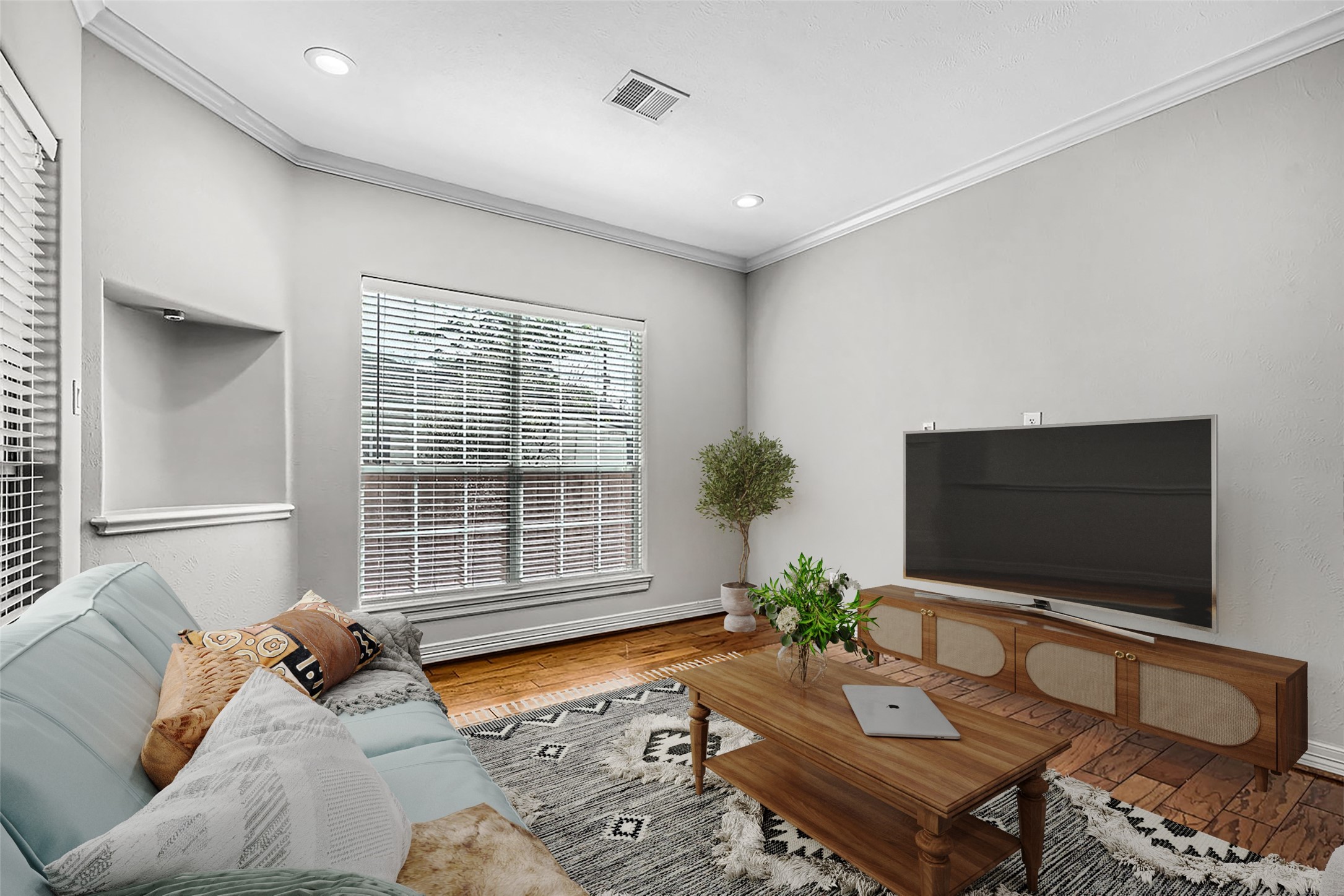 806 East 29th Street Houston, TX 77009 - Photo 5 of 30 This inviting living room features natural light from large windows, hardwood floors, and modern recessed lighting. It offers a cozy seating area, perfect for relaxation and entertainment. *This photo is virtually staged.