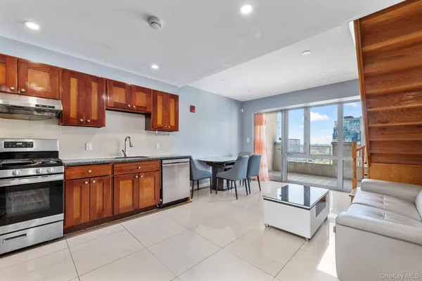 a large kitchen with stainless steel appliances granite countertop a stove a sink and a microwave