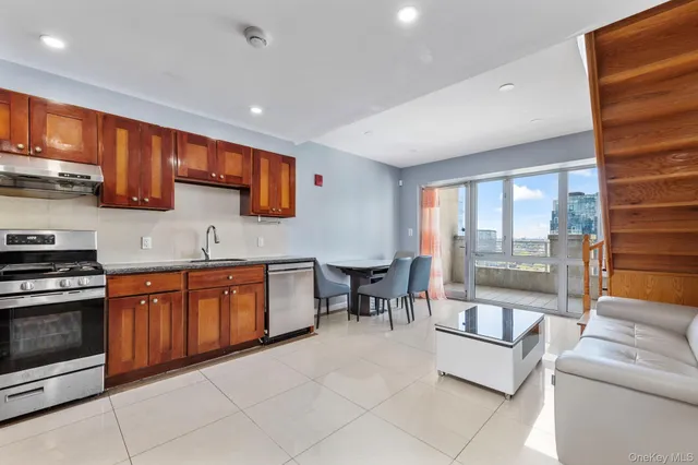 a large kitchen with stainless steel appliances granite countertop a stove a sink and a microwave