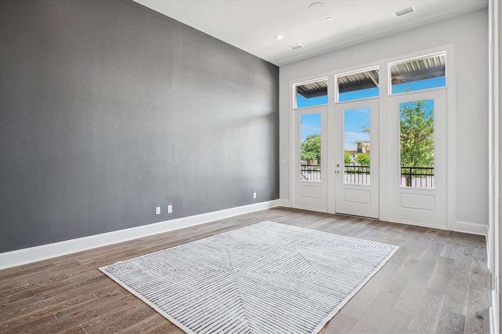 4122 Belt Line Road Addison, TX 75001 - Photo 5 of 36 an empty room with wooden floor and windows