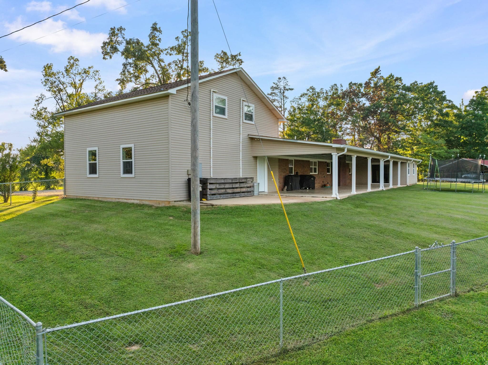 66 County Road 511 Corinth, MS 38834 - Photo 32 of 40 Expansive rear yard featuring green lawn, a chain-link fence, and mature trees