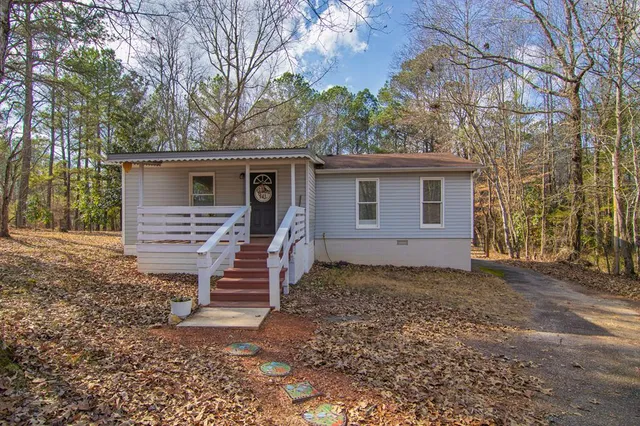 a front view of house with yard and trees around