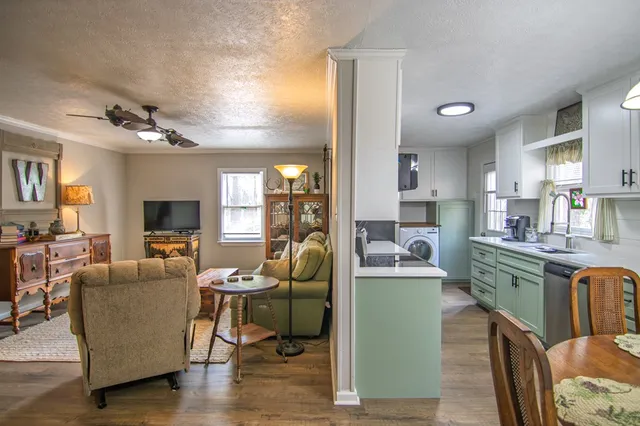 a kitchen with stainless steel appliances granite countertop a stove a kitchen island a dining table and chairs with wooden floor