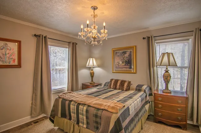 a bedroom with a large bed and a chandelier