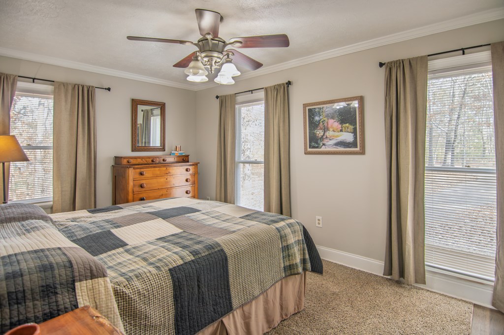 10933 Us Highway Hamilton, GA 31811 - Photo 28 of 44 a bedroom with a large bed and a chandelier