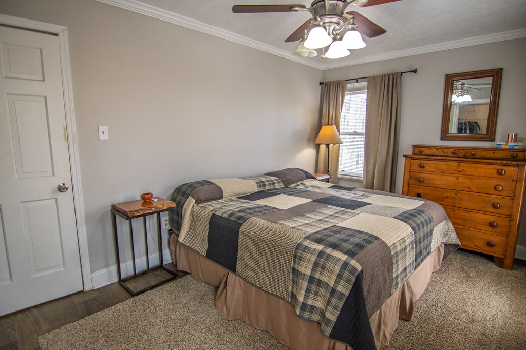 10933 Us Highway Hamilton, GA 31811 - Photo 29 of 44 a bedroom with a bed and a chandelier