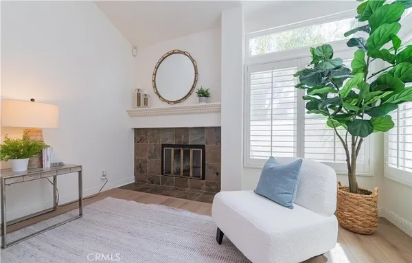 a living room with furniture a potted plant and a fireplace