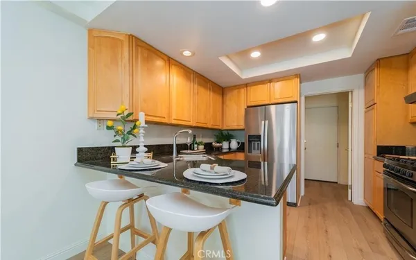 a kitchen with stainless steel appliances kitchen island granite countertop a table and chairs in it