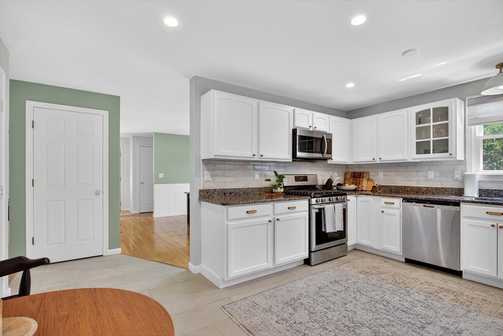 34 Timberline Road Millis, MA 02054 - Photo 11 of 42 a kitchen with stainless steel appliances granite countertop a stove top oven a sink dishwasher a refrigerator and a microwave oven with white cabinets