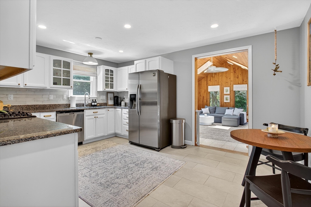 34 Timberline Road Millis, MA 02054 - Photo 9 of 42 a kitchen with stainless steel appliances granite countertop a refrigerator a sink a stove a dining table and chairs