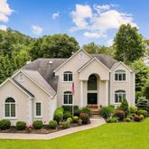 a view of a white house with a yard and potted plants