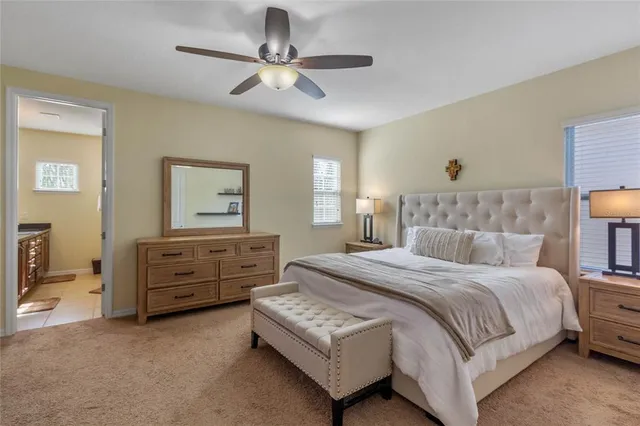 a bedroom with a bed chandelier and dresser