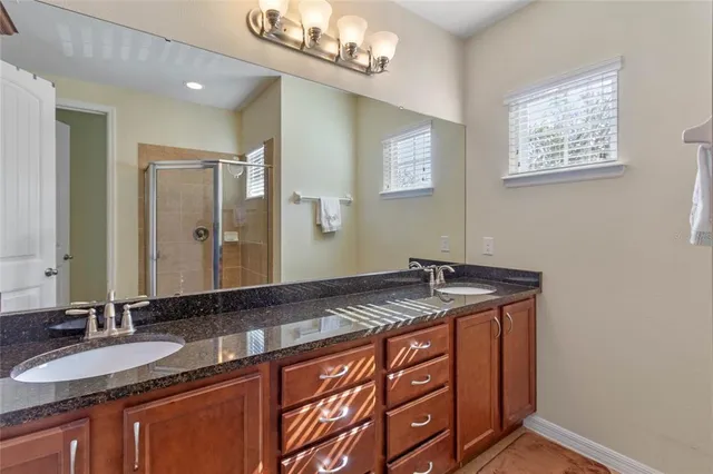 a bathroom with a granite countertop sink and a mirror