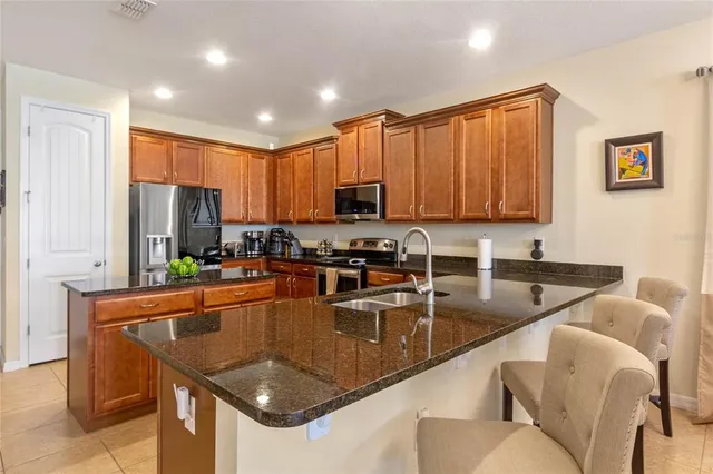 a kitchen with stainless steel appliances granite countertop a sink refrigerator and microwave