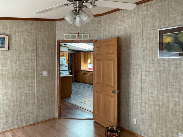 a view of a hallway with wooden floor and chandelier