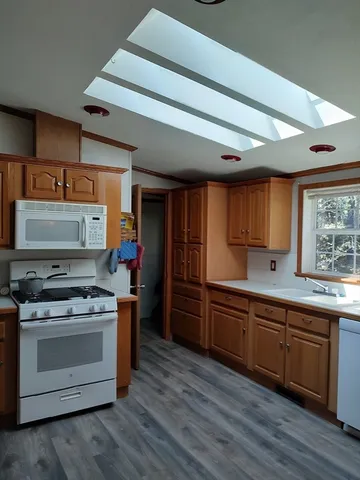 a kitchen with stainless steel appliances a stove and wooden floor