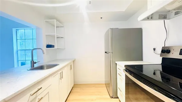 a kitchen with stainless steel appliances granite countertop a sink and a refrigerator