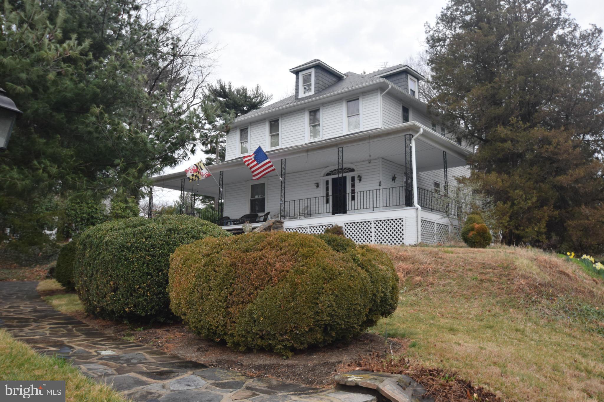 a view of a white house with large trees and outdoor space