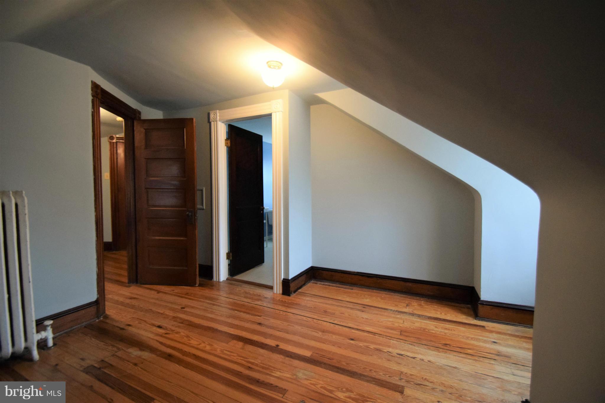 601 Charing Cross Road Baltimore, MD 21229 - Photo 22 of 30 a view of an empty room with wooden floor and a window