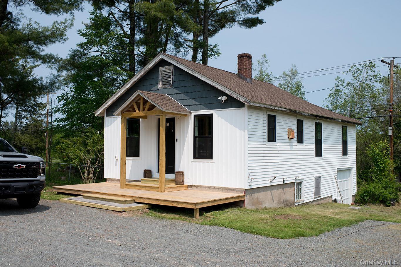 1132 Old Rte 17 Harris, NY 12742 - Photo 3 of 26 View of front of property featuring a shingled roof, a chimney, a deck, and board and batten siding