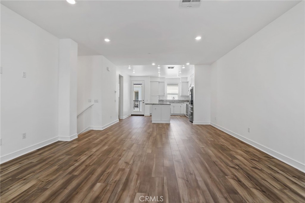 454 Palermo Lake Forest, CA 92630 - Photo 13 of 44 a view of empty room with wooden floor and kitchen