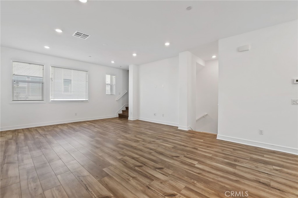 454 Palermo Lake Forest, CA 92630 - Photo 14 of 44 an empty room with wooden floor and windows
