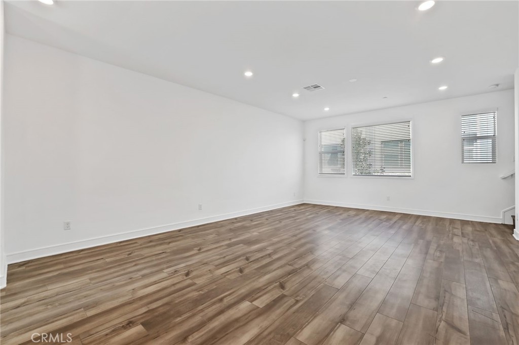 454 Palermo Lake Forest, CA 92630 - Photo 16 of 44 an empty room with wooden floor and windows