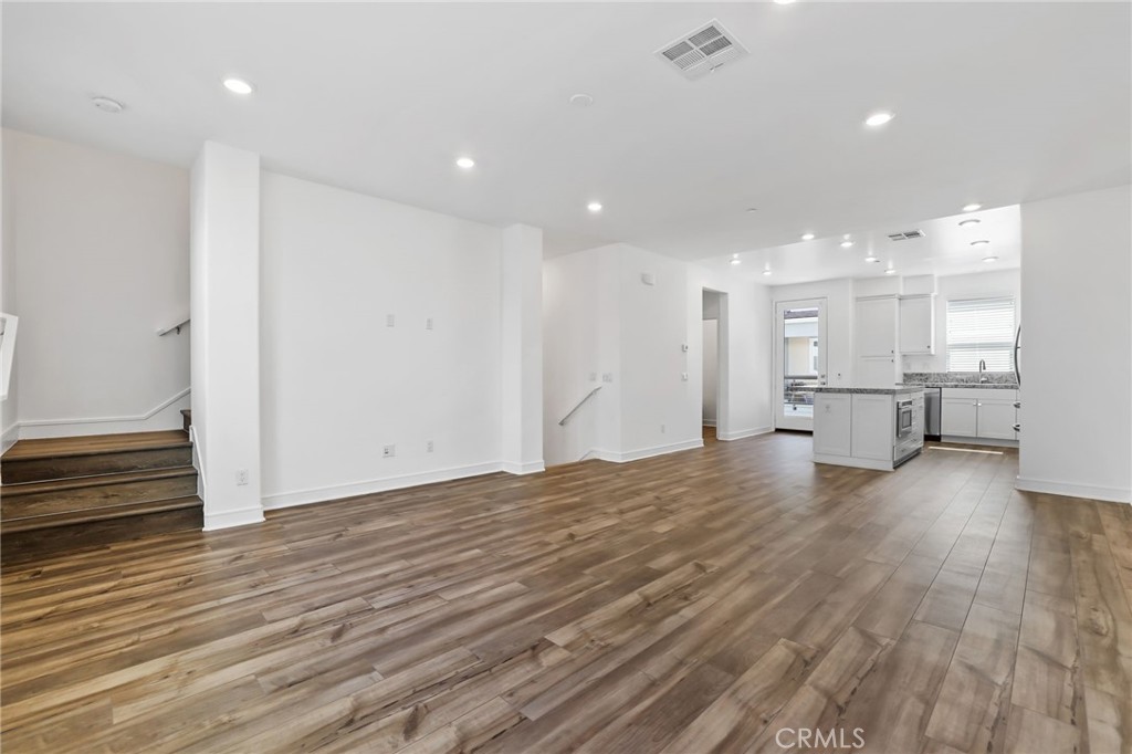 454 Palermo Lake Forest, CA 92630 - Photo 17 of 44 a view of kitchen and empty room with wooden floor