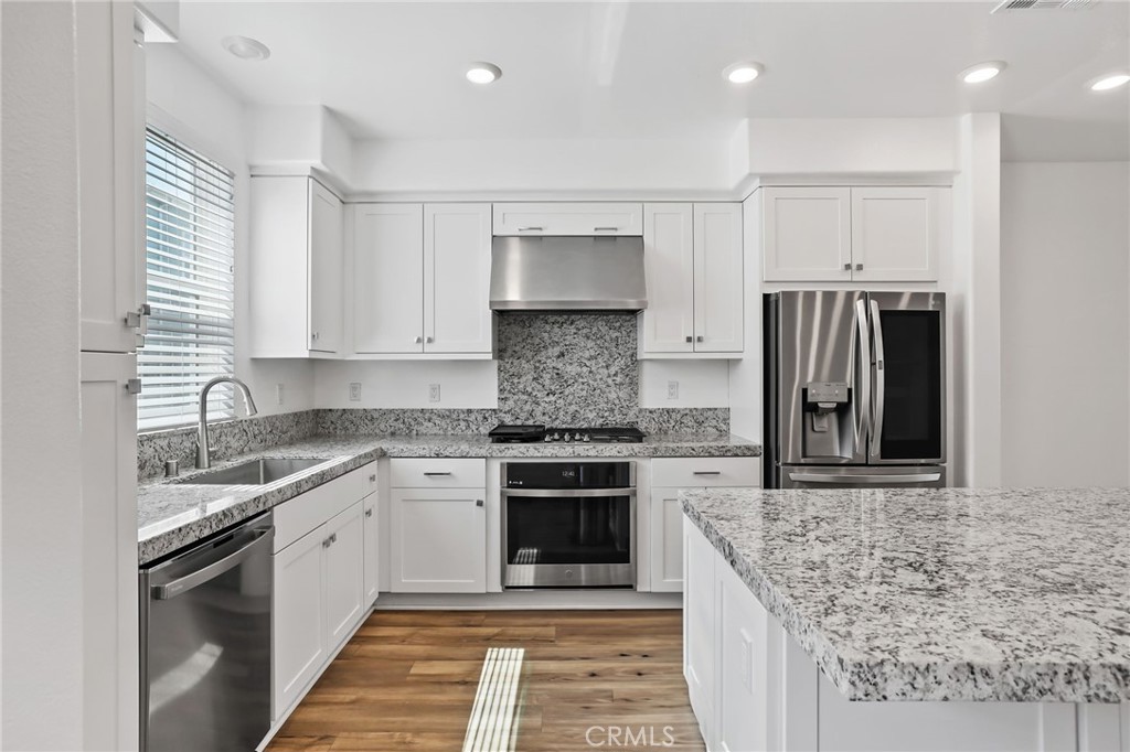 454 Palermo Lake Forest, CA 92630 - Photo 7 of 44 a kitchen with stainless steel appliances granite countertop a stove sink and cabinets
