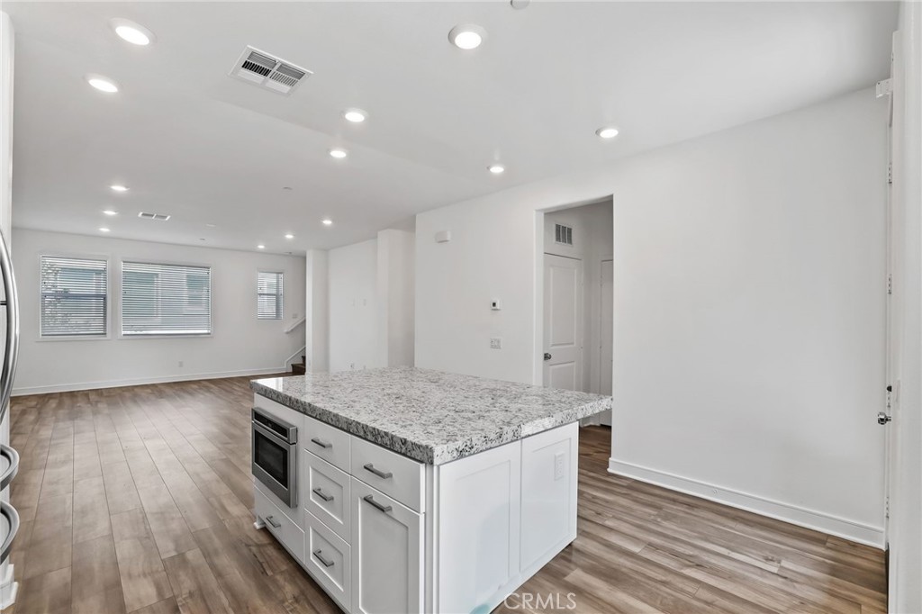 454 Palermo Lake Forest, CA 92630 - Photo 9 of 44 a view of kitchen island wooden floor center island and stainless steel appliances