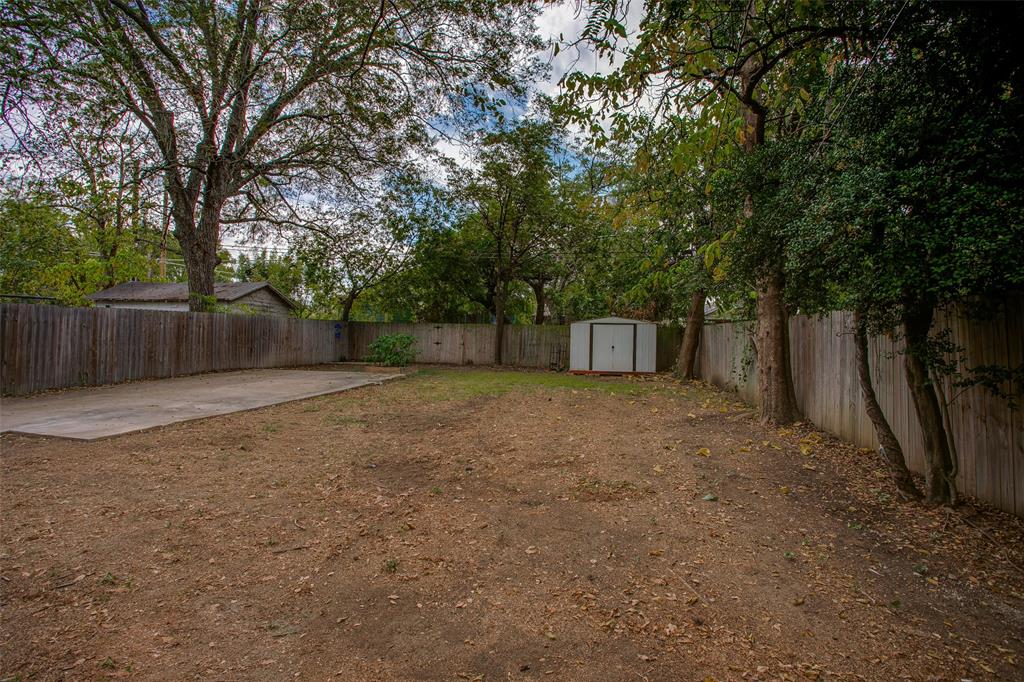2606 West 12th Street Dallas, TX 75211 - Photo 35 of 36 a view of a backyard with large trees and wooden fence